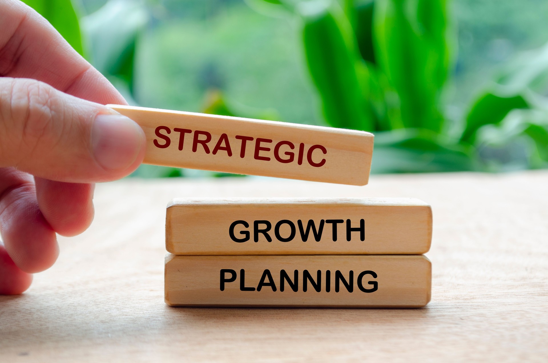 Hand putting Growth Planning text on wooden block. Business strategy and growth concept.